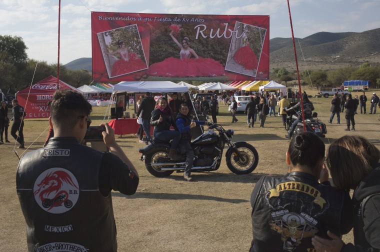 Image: A couple, who traveled from Mexico City with a group of bikers, pose for a photo at Rubi's quinceanera