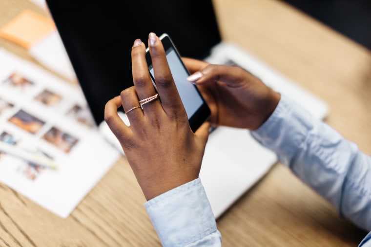 Hands of black businesswoman using smart phone
