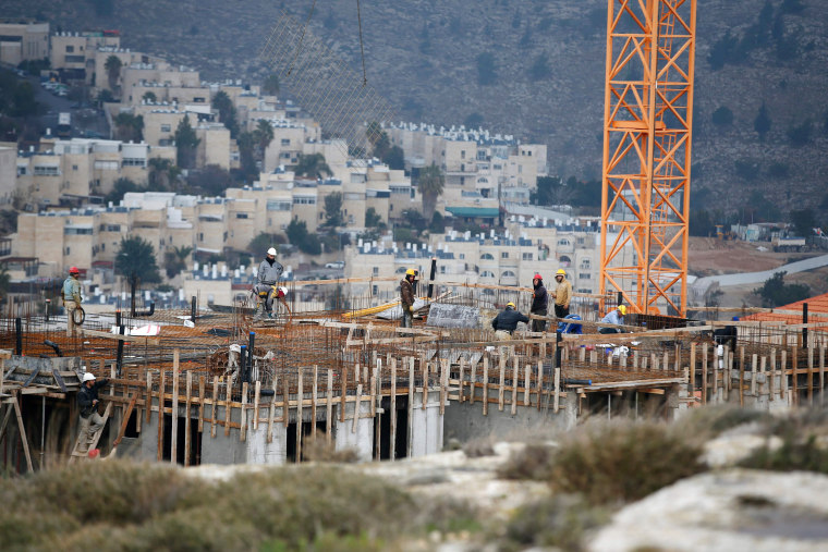 Image: Construction workers at a building site of new housing units in the Jewish settlement of Neve Yaakov