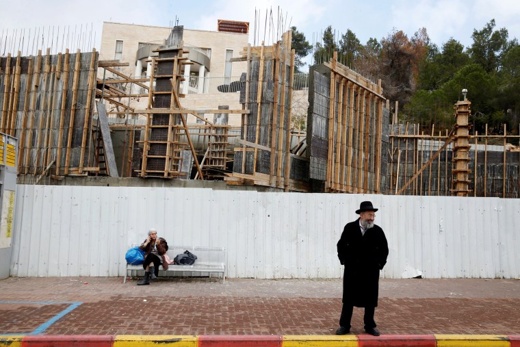 Image: Israelis are seen near a construction site in the Israeli settlement of Ramat Shlomo, in the occupied West Bank