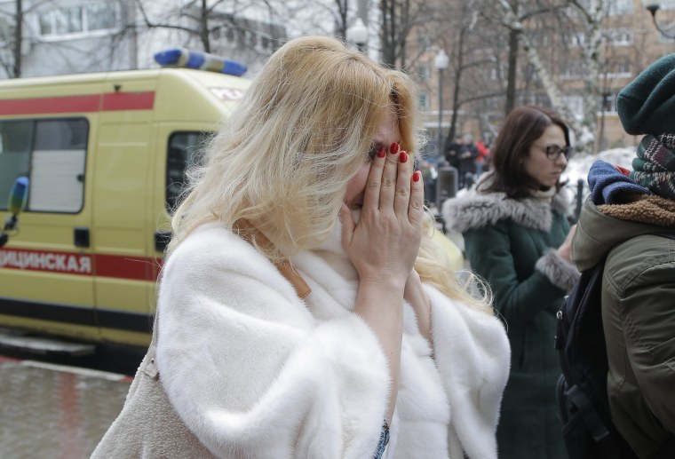 Image: A mourner covers her face near a temporary shrine outside the home stage of the Alexandrov Ensemble, or Red Army Choir, in Moscow.