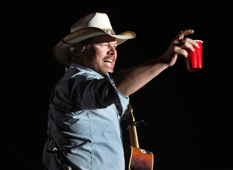 Toby Keith toasts his fans with a red solo cup, the name of one of his hit songs on the Mane Stage