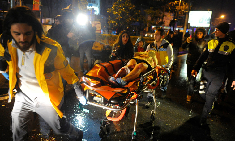 Image: An injured woman is carried to an ambulance from a nightclub where a gun attack took place during a New Year party in Istanbul