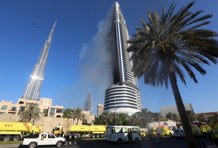 Image: Plumes of smoke rise from the 63-storey Address Downtown Dubai hotel and residential block near the Burj Khalifa in Dubai
