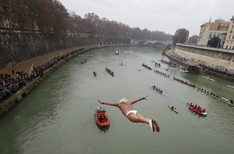 Image: Palmulli of Italy dives into the Tiber River from the Cavour bridge, as part of traditional New Year celebrations in Rome