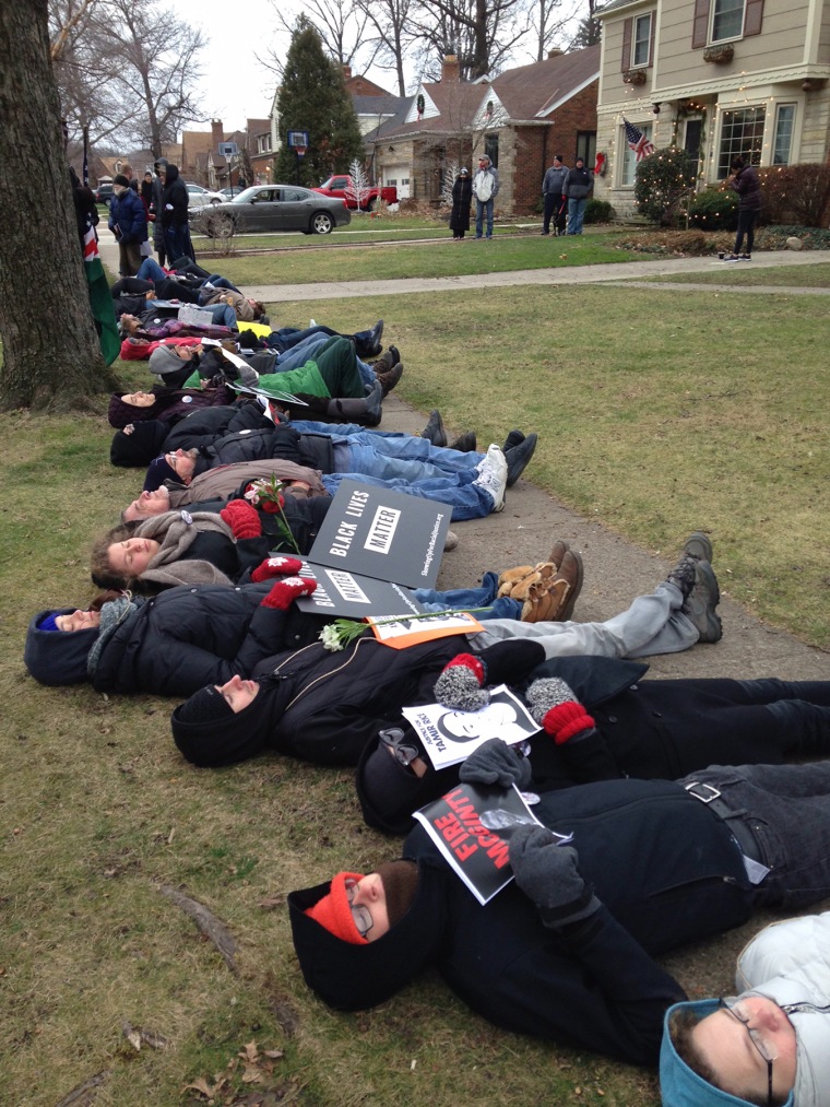 In this photo provided by cleveland.com, protesters upset over a grand jury's decision not to indict two officers in Tamir Rice's death lie down on the ground near the home of Cuyahoga County Prosecutor Tim McGinty in Cleveland on Friday, Jan. 1, 2016.