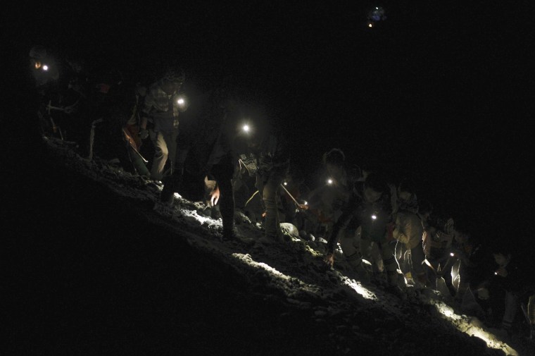 Image: Miners search for jade stones at a mine dump at a Hpakant jade mine in Kachin state