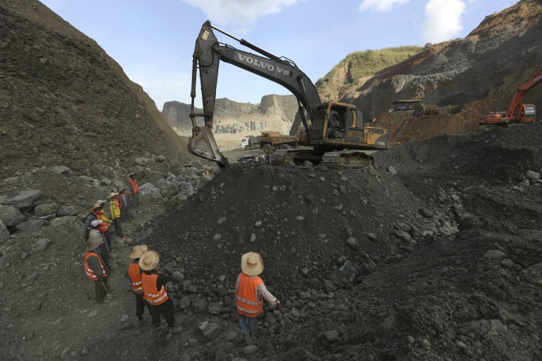 Image: Miners search for jade stones at a mine dump at a Hpakant jade mine in Kachin state