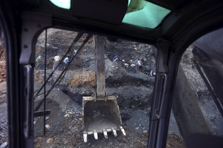 Image: Miners search for jade stones at a mine dump at a Hpakant jade mine in Kachin state