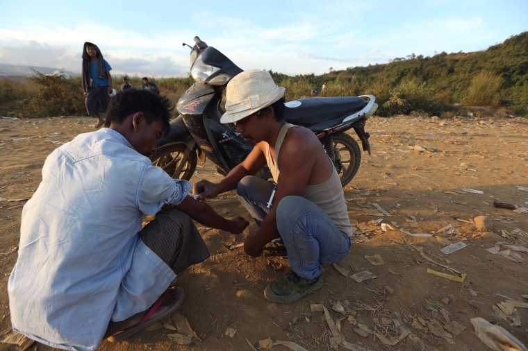 Image: Two miners inject heroin into each other at a mine dump at a Hpakant jade mine in Kachin state