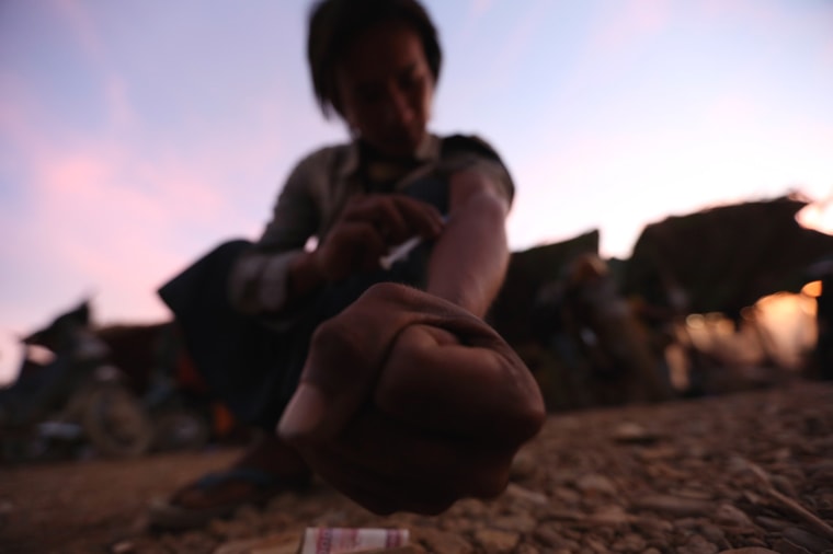 Image: A miner injects heroin at a mine dump at a Hpakant jade mine in Kachin state