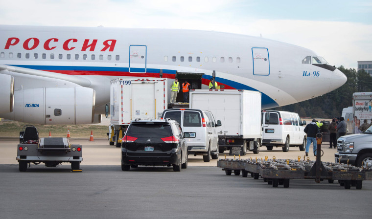 Image: Vehicles pull up to a Russian aircraft to load freight