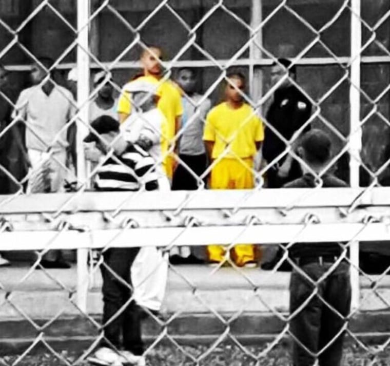 Venezuelan activists Francisco Marquez, left, and Miguel San Miguel, right, in yellow, stand outside the July 26 prison in San Juan de los Morros, Venezuela