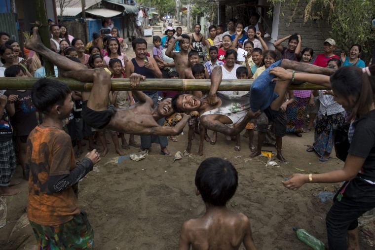 Image: Young people play a traditional pillow fight game on a bamboo pole during festivities marking the 69th anniversary of Myanmar Independence Day on the outskirts of Yangon on Jan. 4.