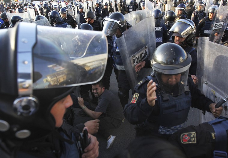 Image: Police forcibly remove demonstrators who blocked a main road for about an hour as they protest hikes in gas prices in Mexico City on Jan. 4.