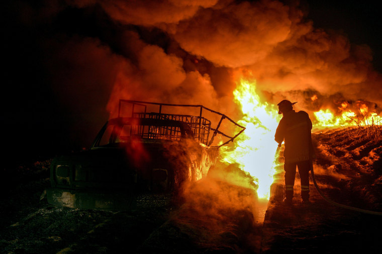 Image: Firefighters work to quell a fire on an alleged clandestine gasoline storage