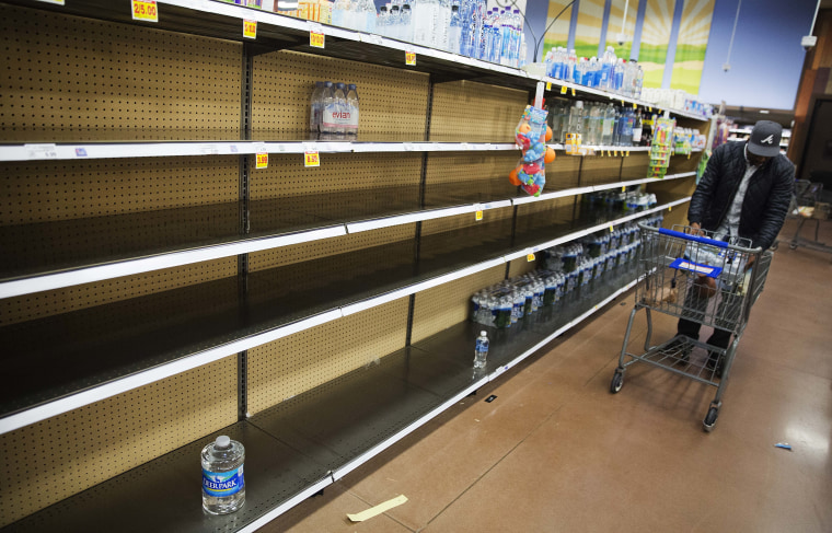 Image: Shelves of bottles of water sit mostly empty at a supermarket in Atlanta, Friday.