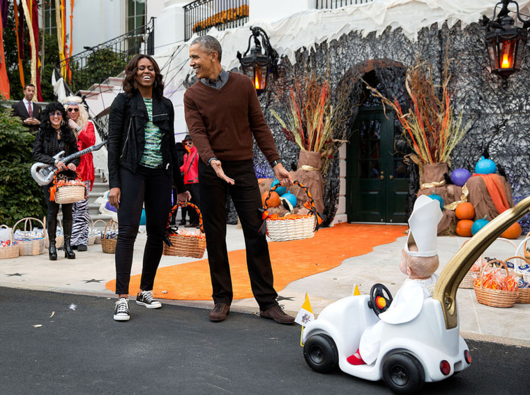 The president and first lady react to a child in a pope costume and mini popemobile as they welcomed children during a Halloween event on the South Lawn of the White House on Oct. 30, 2015.