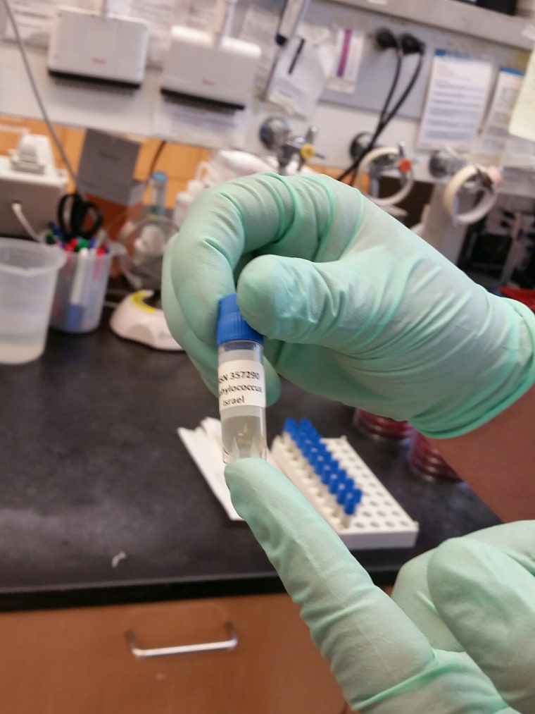 A researcher at Walter Reed Army Institute for Research holds a sample being tested for superbugs.