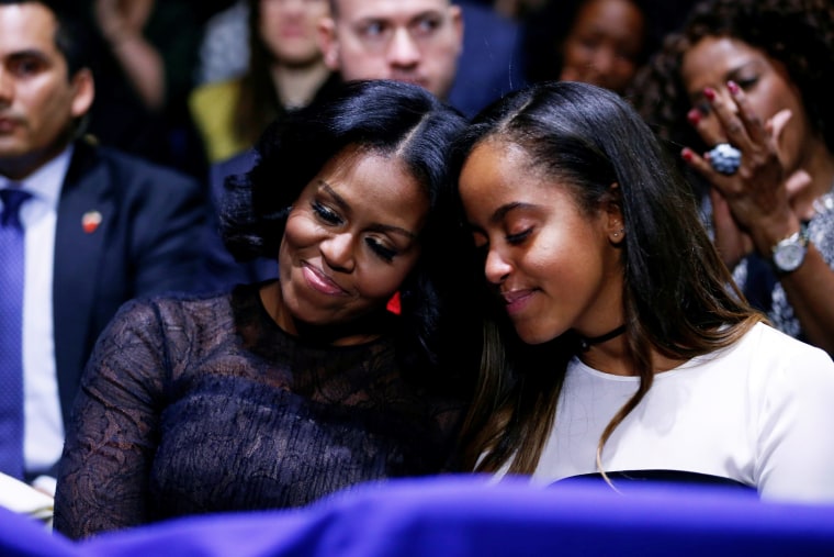 Image: First Lady Michelle Obama and her daughter Malia embrace as President Obama praises them during his farewell address in Chicago, Illinois on Jan. 10.