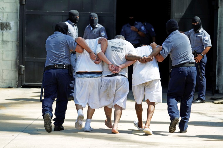 Mara Salvatrucha (MS-13) gang members are escorted upon their arrival at the maximum security jail in Zacatecoluca