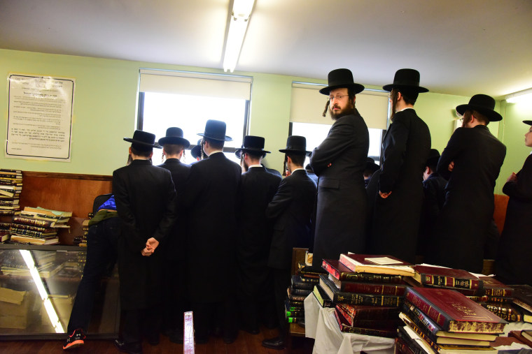 Students watch funeral from second floor of yeshiva.