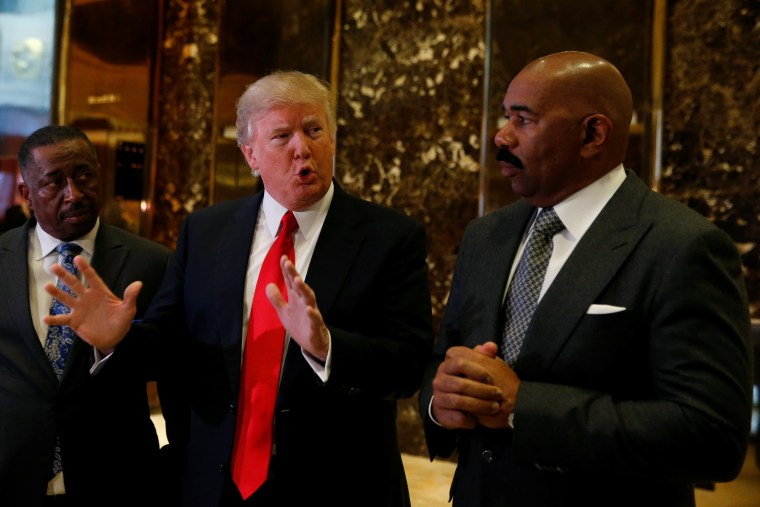 Image: U.S.President-elect Donald Trump speaks to members of the news media with television personality Steve Harvey (R) and businessman Greg Calhoun after their meeting at Trump Tower in New York