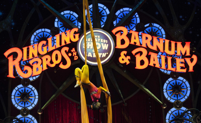 Image: A performer hangs upside down during a Ringling Bros. and Barnum &amp; Bailey Circus performance