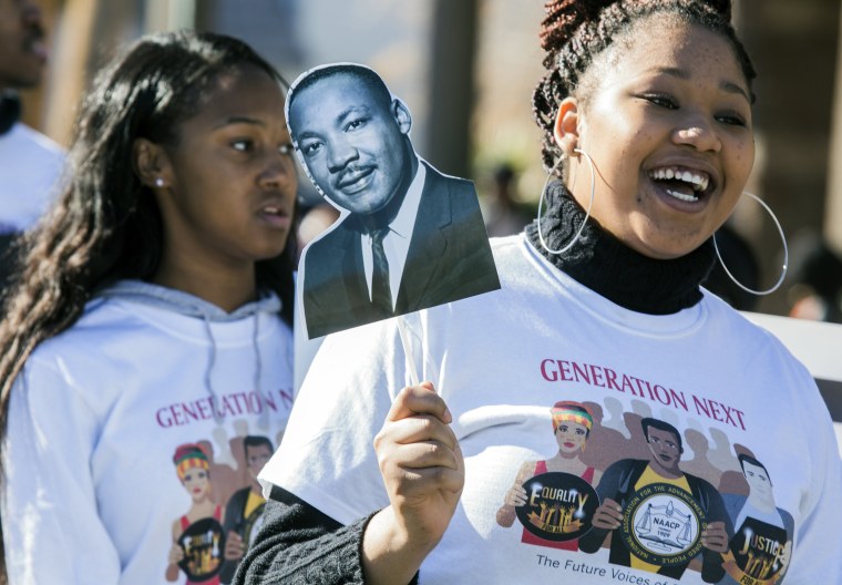 Image: I'yanne Davis holds an image of Martin Luther King Jr. during a parade in King's honor in downtown Las Vegas, Nevada on Jan. 16.
