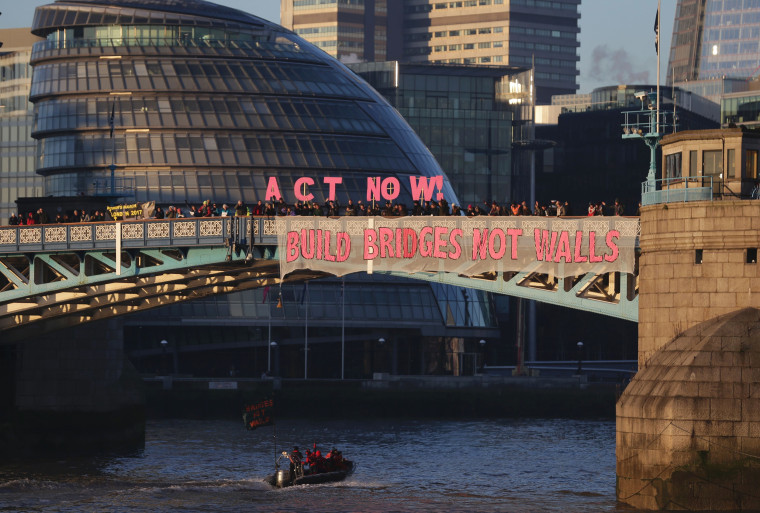 Image: Activists from the Bridges not Walls movement display messages on Tower Bridge in London