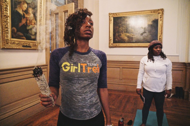 Wordna Warren of Washington D.C. burns sage to cleanse the space to prepare to receive positive energy at GirlTrek’s day of #BlackGirlHealing event.