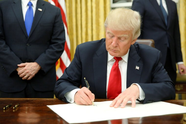 Image: President Donald Trump signs his first executive orders in the Oval Office in Washington, D.C. on Jan. 20.