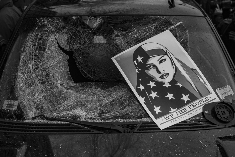 Image: Protesters leave an anti-Trump poster on top of a parked limousine broken during a demonstration on Jan. 20.