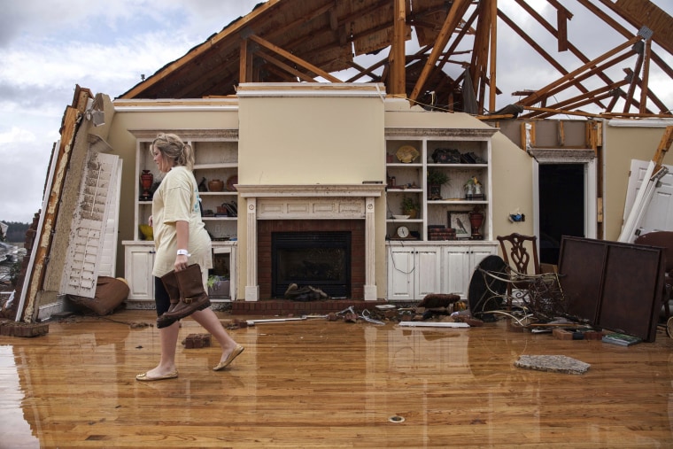 Image: Jenny Bullard carries a pair of boats from her home that was damaged by a tornado, Jan. 22, 2017, in Adel, Georgia.