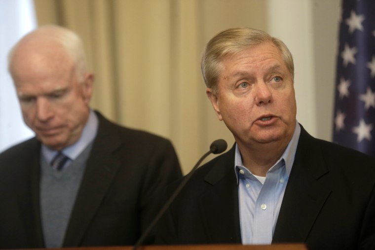 Image: U.S. Senator McCain listens as Senator Graham speaks during a news conference in Riga