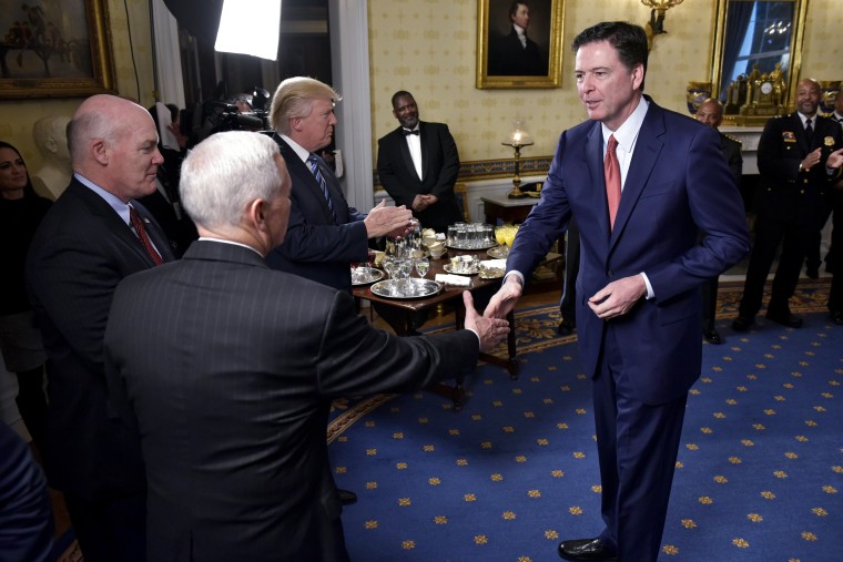 Image: Vice President Pence shakes hands with FBI Director James Comey, watched by Secret Service Director Joseph Clancy and President Trump during the reception for law enforcement officers.