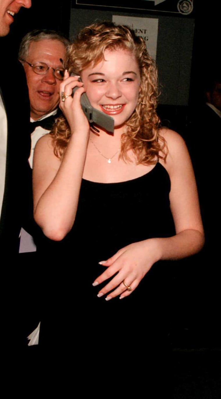 American country and pop singer LeAnn Rimes talks on a cellular phone just after winning Best New Artist at the Grammy Awards, New York, February 26, 1997.