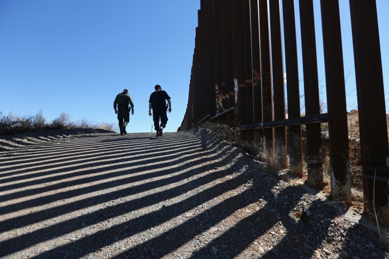 Image: U.S. Customs and Border Protection personnel walk along the U.S.-Mexico border