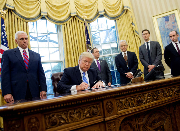 Image:  Trump signs an executive order in the Oval Office