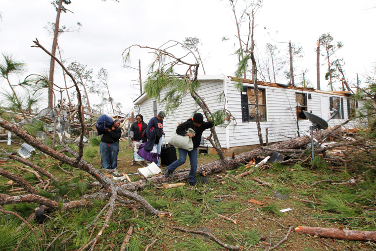 Image: Richardson, Daly, Vaughn and Furlow remove belongings from their home after a tornado struck the residential area on Sunday in Albany