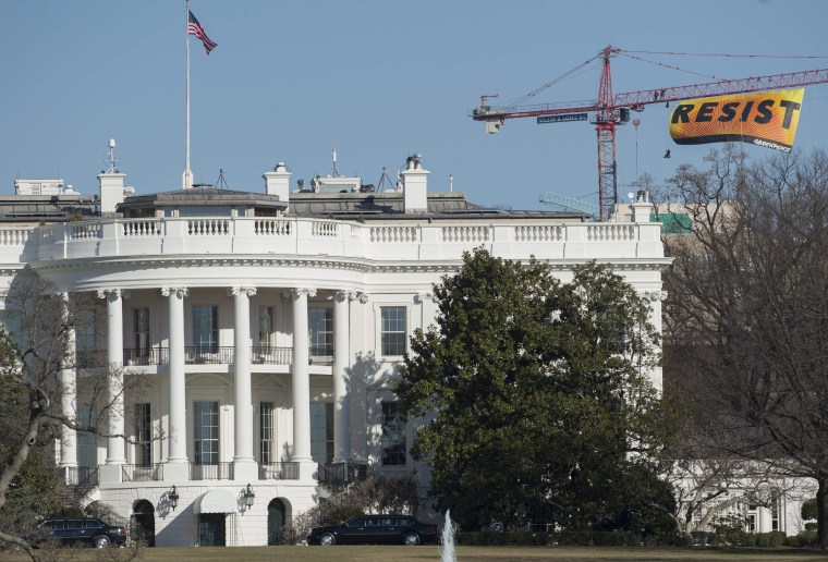 Image: Greenpeace protesters unfold a \"Resist\" banner from a construction crane near the White House on Wednesday.
