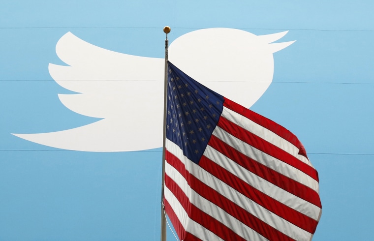 Image: The Twitter logo is shown with the U.S. flag in New York on Nov. 7, 2013.