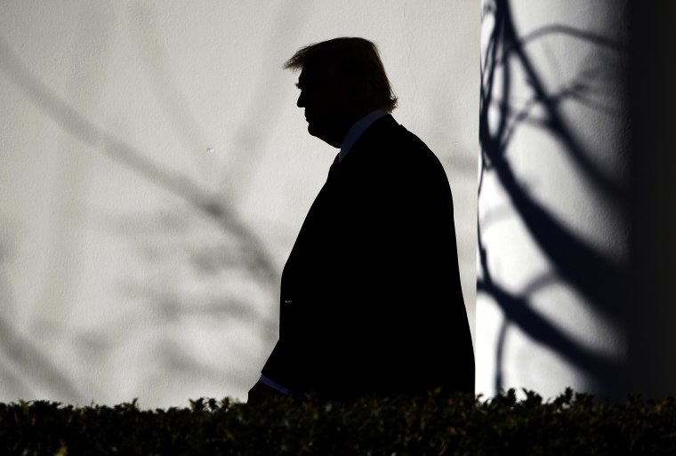 Image: President Donald Trump walks through the Colonnade to the Oval Office after returning to the White House in Washington on Jan. 26.