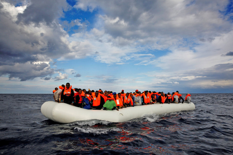 Image: An overcrowded raft drifts out of control in the central Mediterranean Sea