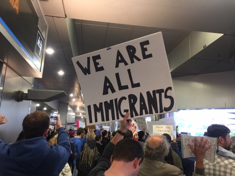 Demonstrator in Miami holds up sign for immigrants