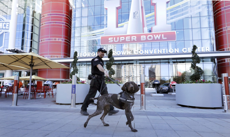 Image: Officer Keith McCart, of the Long Beach, Calif. Police Department, patrols with K-9 Pidura outside the George R. Brown Convention Center, the NFL Super Bowl 51 football media center and site of the NFL Experience, Jan. 31, 2017, in Houston.