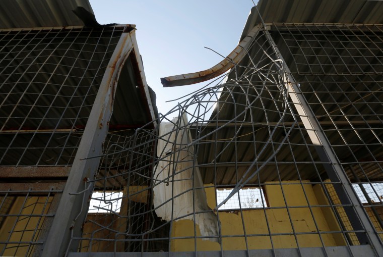 Image: A cage which was hit by shell, allowing monkeys to escape, is seen at Nour Park in Mosul's zoo