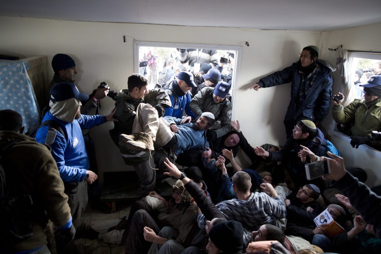 Image: Israeli security forces try to arrest settlers who hold each other in a house during the evacuation of the illegal Jewish settlement of Amona, in the West Bank, on Feb. 1.