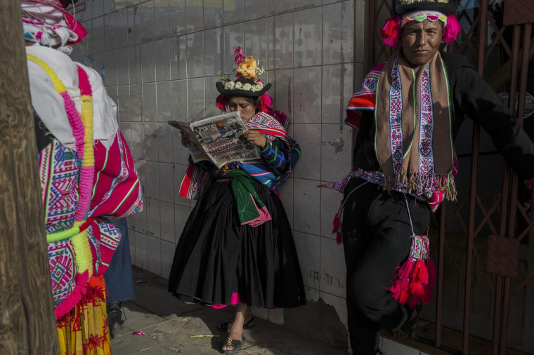 Image: A dancer reads a newspaper while waiting to perform during Virgin of Candelaria celebrations in Puno, Peru on Jan. 29.