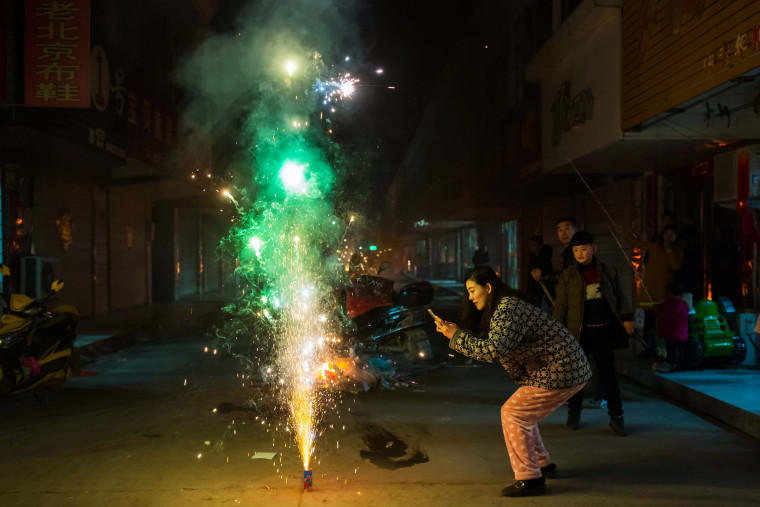 Image: A woman takes pictures of firework on the eve of the Chinese Lunar New Year, or the Spring Festival, in Lianyungang, Jiangsu province, China on Jan. 27.